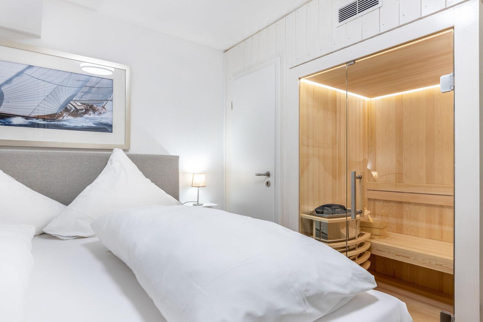 Schlafzimmer mit Doppelbett und integrierter Sauna.