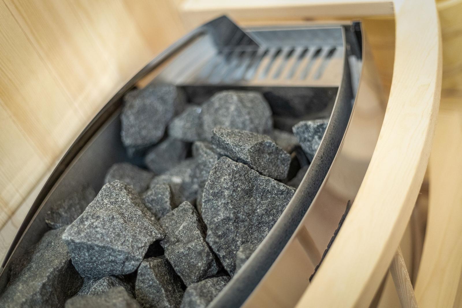 Innere Ansicht einer Sauna mit Steinmulde und Holzrahmen