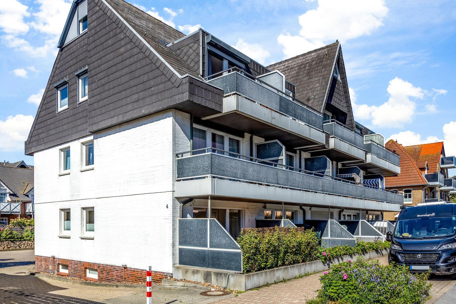 Modernes Mehrfamilienhaus mit Balkonen und dunklem Dach