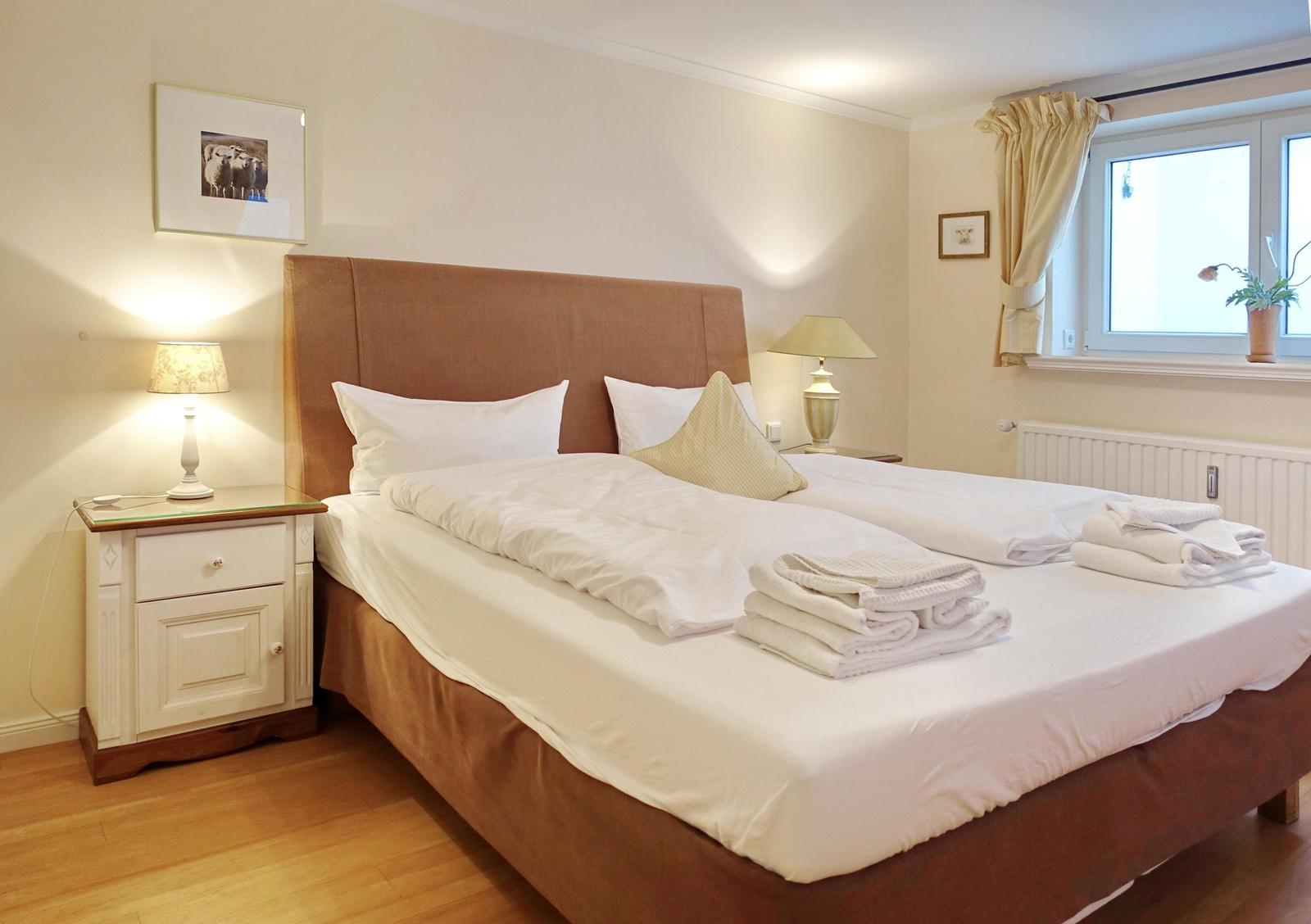Bedroom with double bed, nightstand, and window.