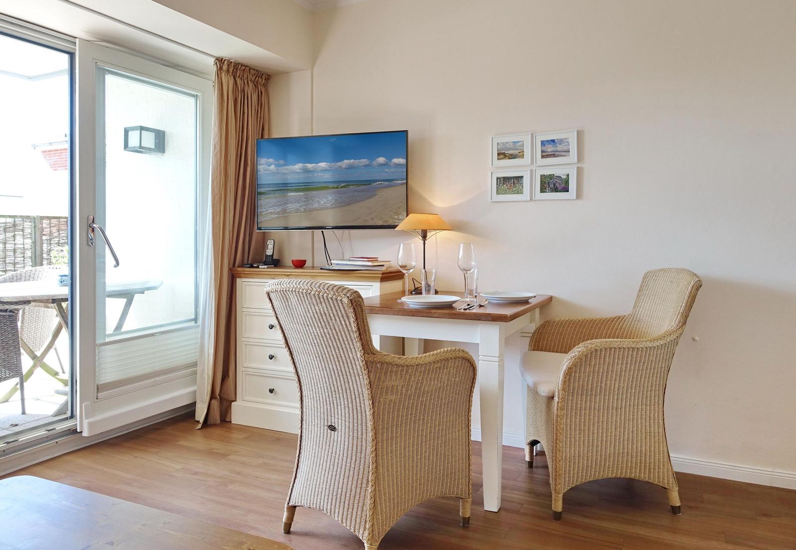 Dining room with table, two chairs, and TV. Access to terrace.