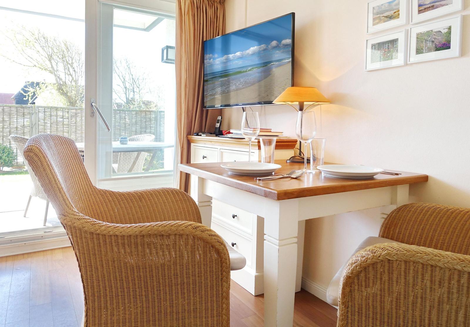 Dining area with table, chairs, and TV. Window to terrace.