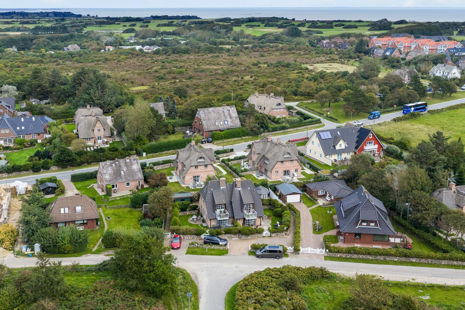 Houses with roofs and green areas in a rural setting.