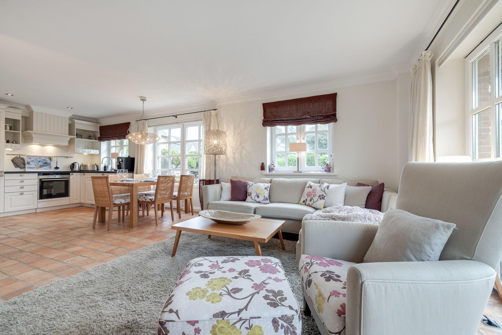 Living and dining area with kitchen and windows.