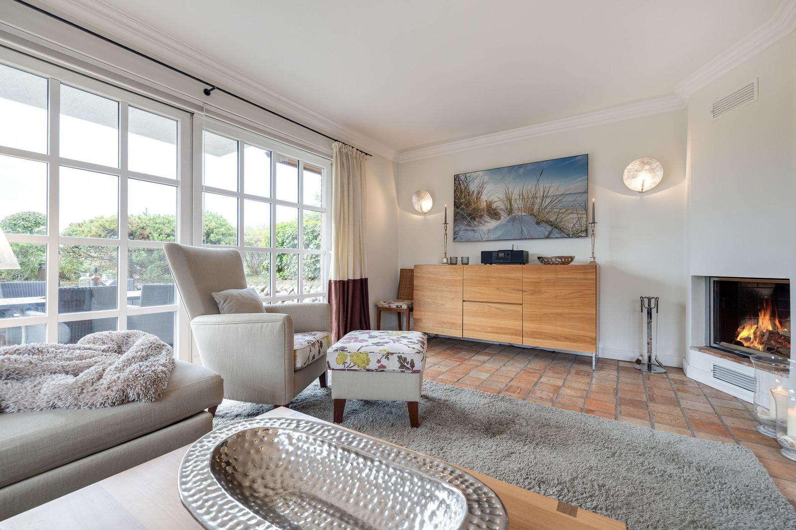 Living room with fireplace, seating, and large window view.