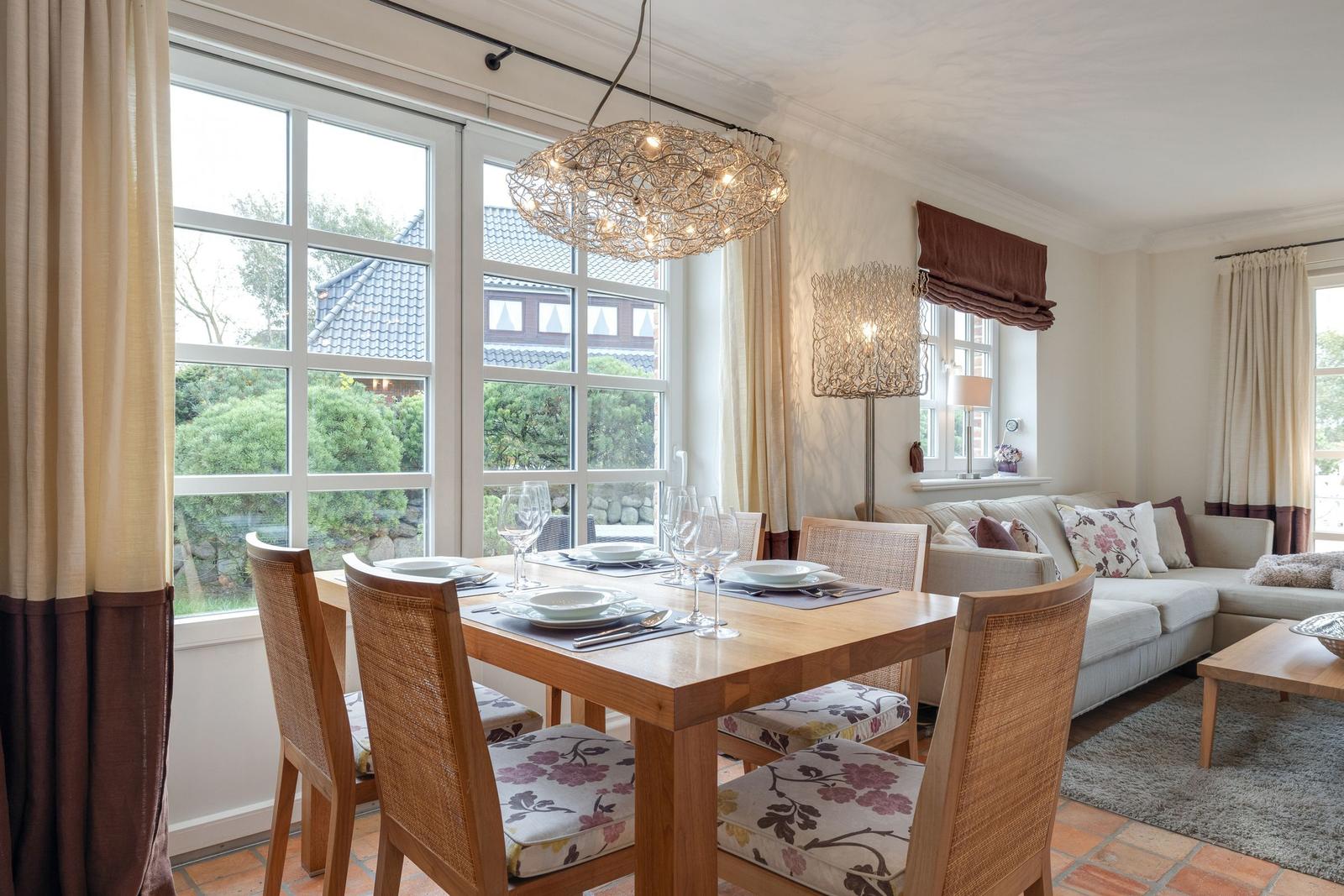 Dining room with table, chairs, and garden view. Living area with sofa and coffee table.