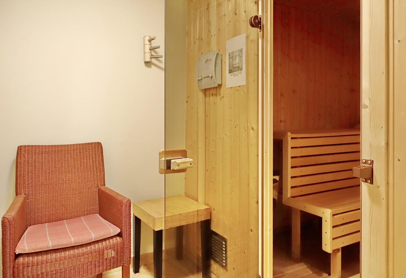 Sauna mit Holzbank und Sitzgelegenheit außerhalb
