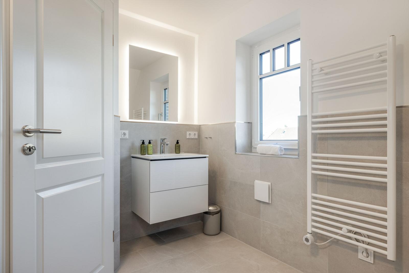 Bathroom with sink, mirror, and window.