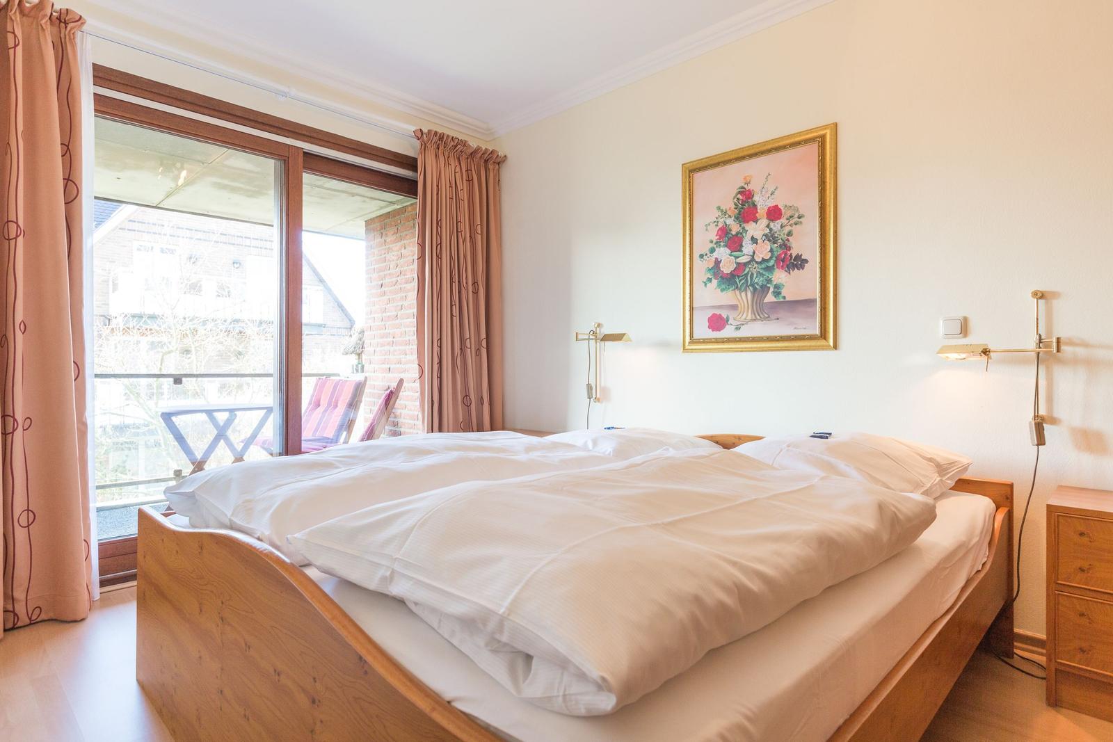 Bedroom with double bed, window, and painting on the wall.