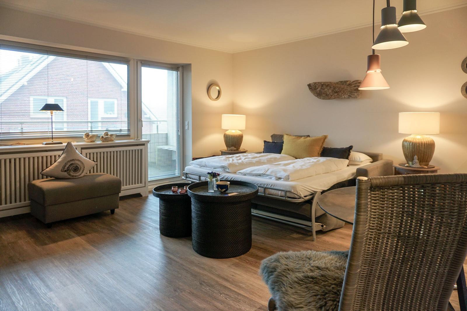 Ein Schlafzimmer mit Bett, Sitzgelegenheiten und Fenster zur Aussicht.