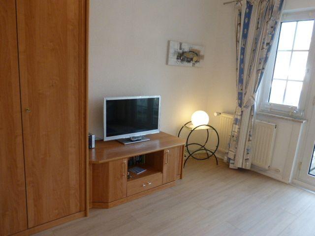 Das Wohnzimmer, mit Farbfernseher , Bücher und Schrank, gegenüber die Couch