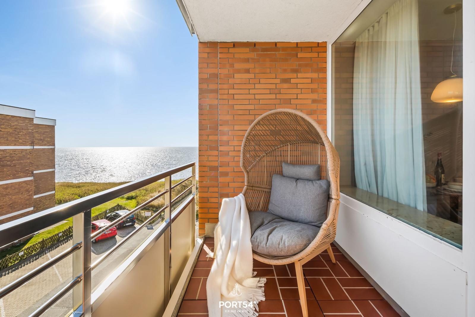 Balcony with wicker chair and sea view