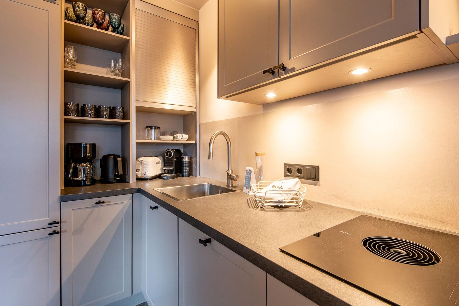 Kitchen with sink, cooktop, and dish racks.