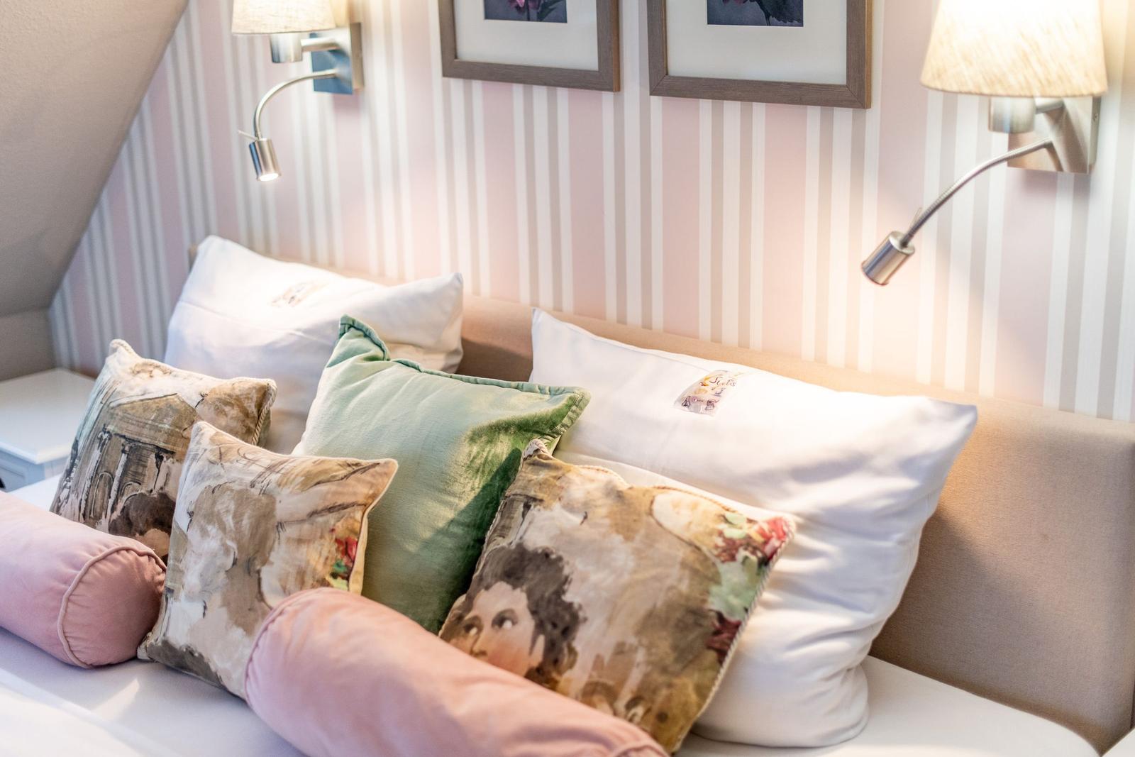Bed head with pillows and wall lamps on striped wall
