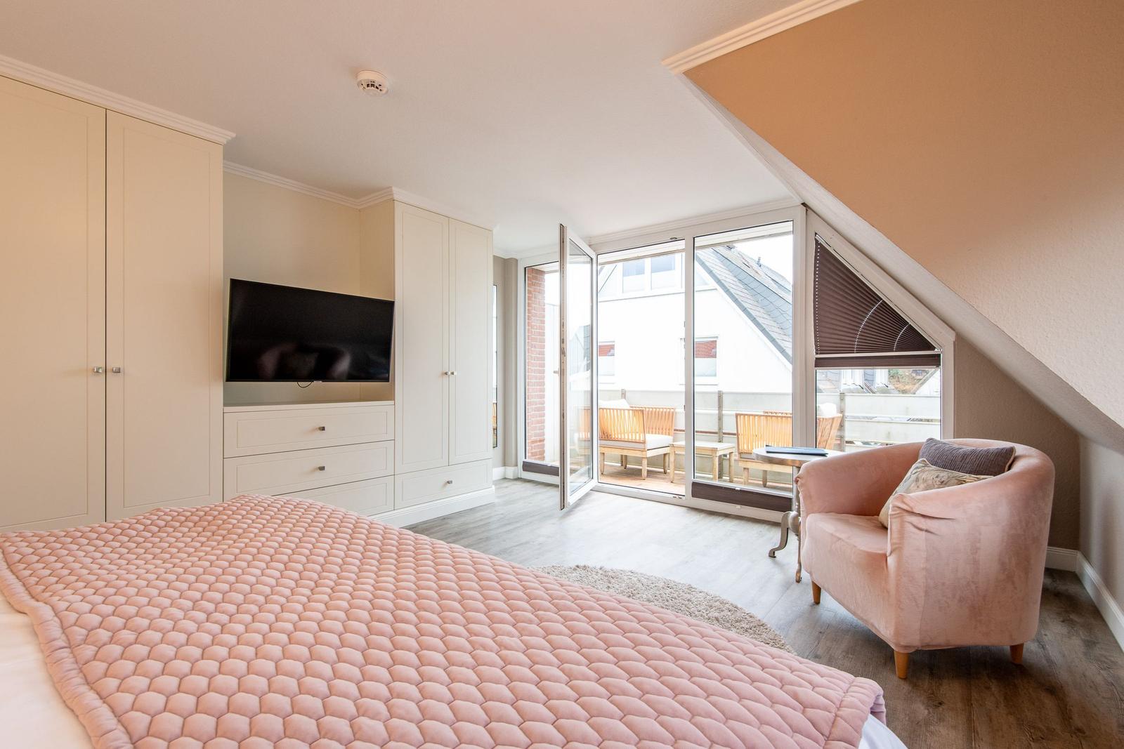 Bedroom with bed, TV, and balcony access.