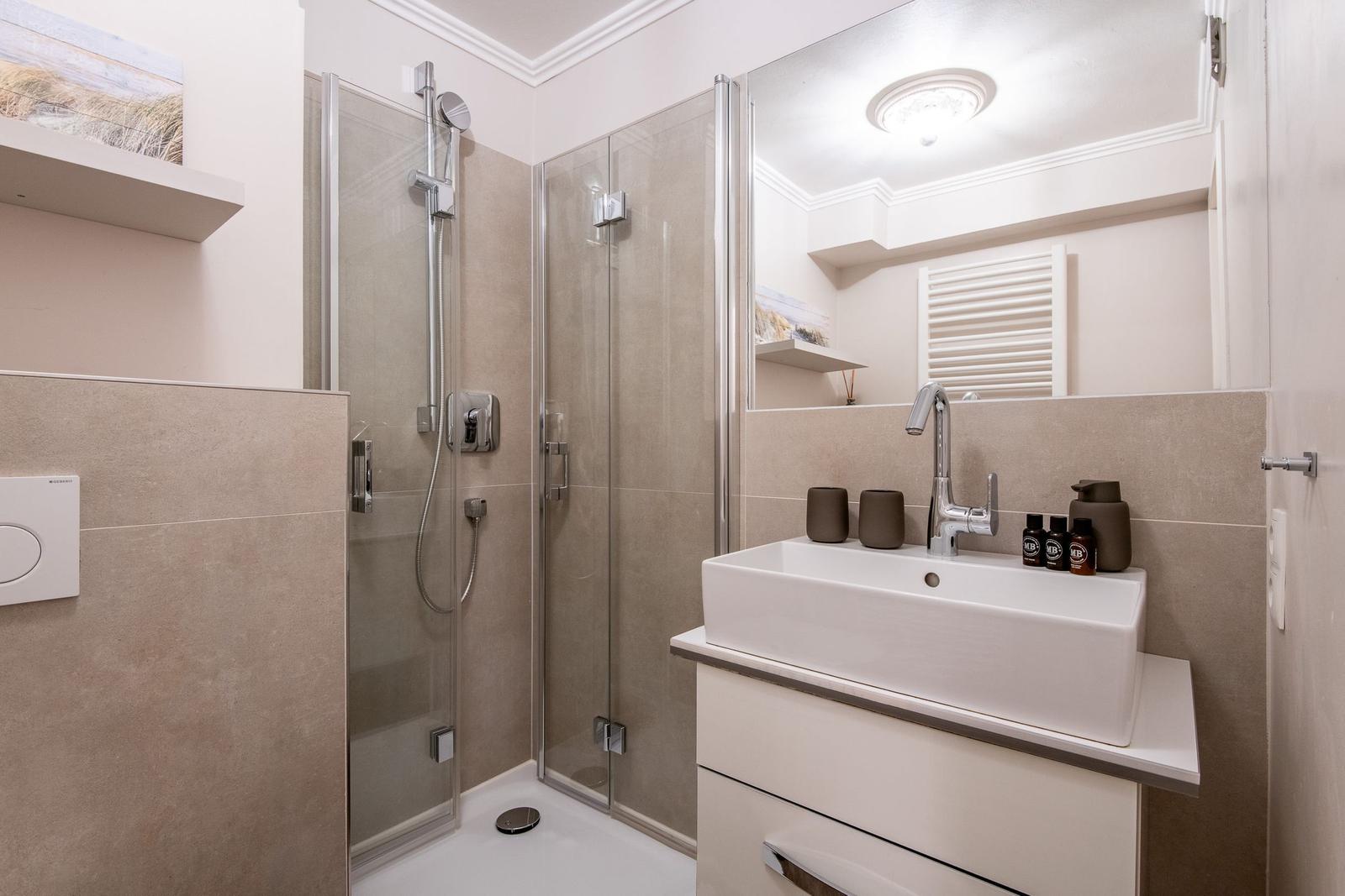 Bathroom with shower, sink, and mirror