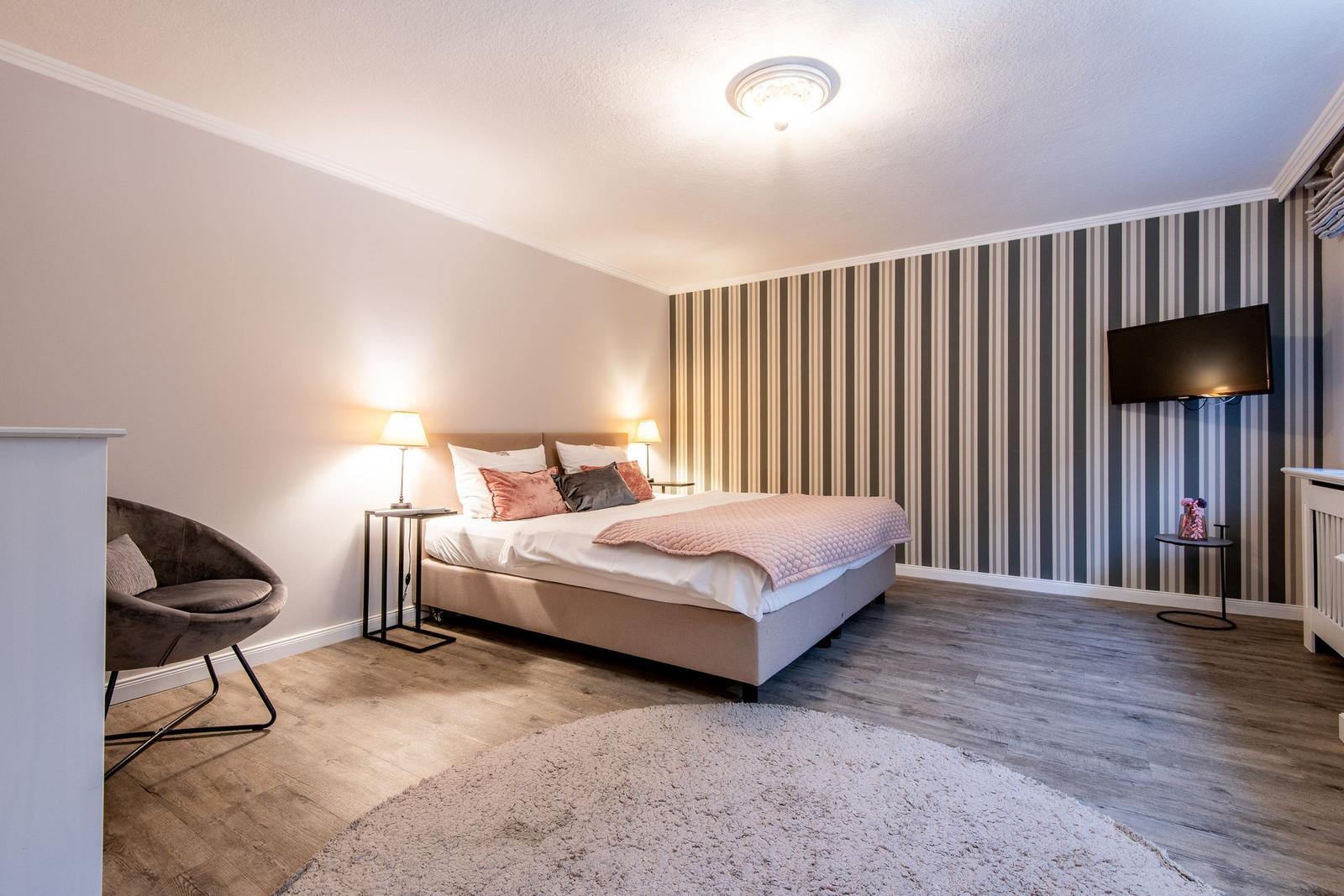 Bedroom with bed, TV, and chair