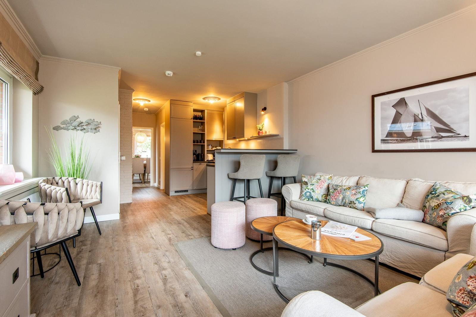 Living area with sofa, coffee table, and view into the kitchen.