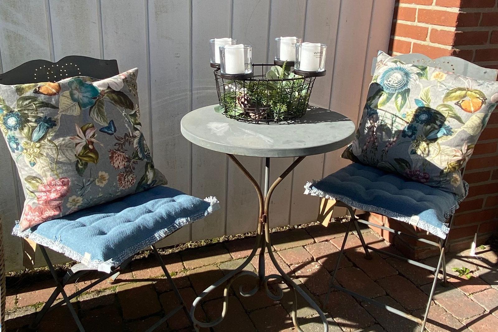 Two chairs with cushions and table on terrace