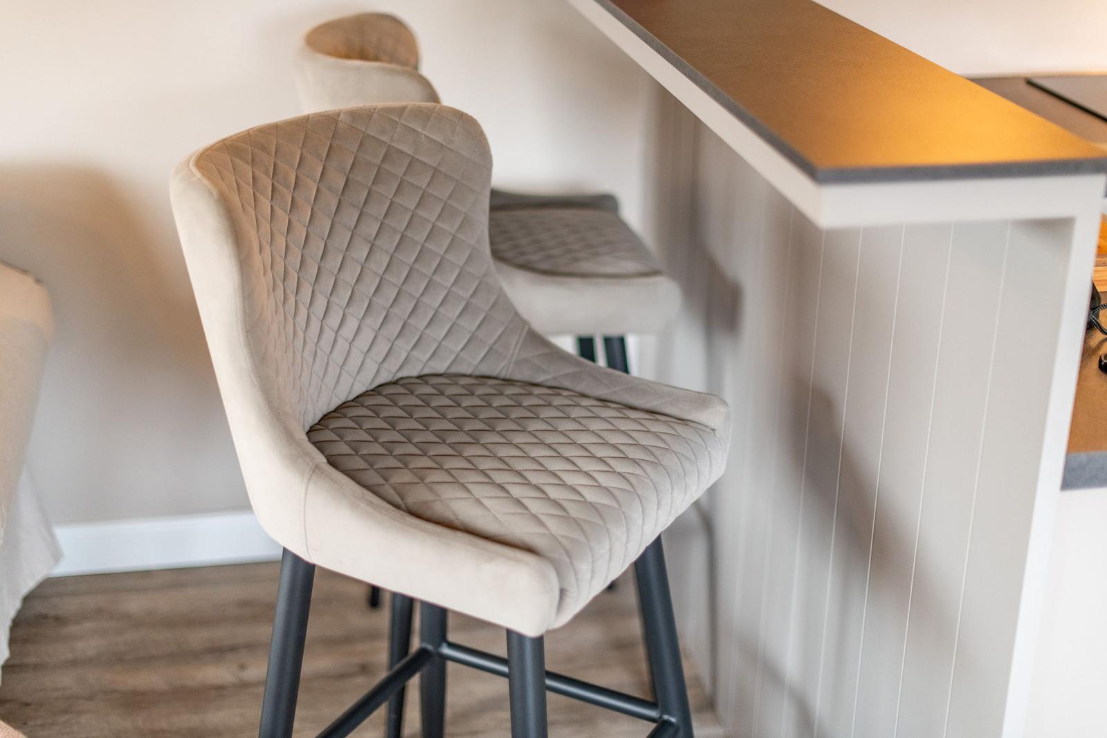 Hochlehnerstühle mit Quiltmuster stehen an der Küchenbar.