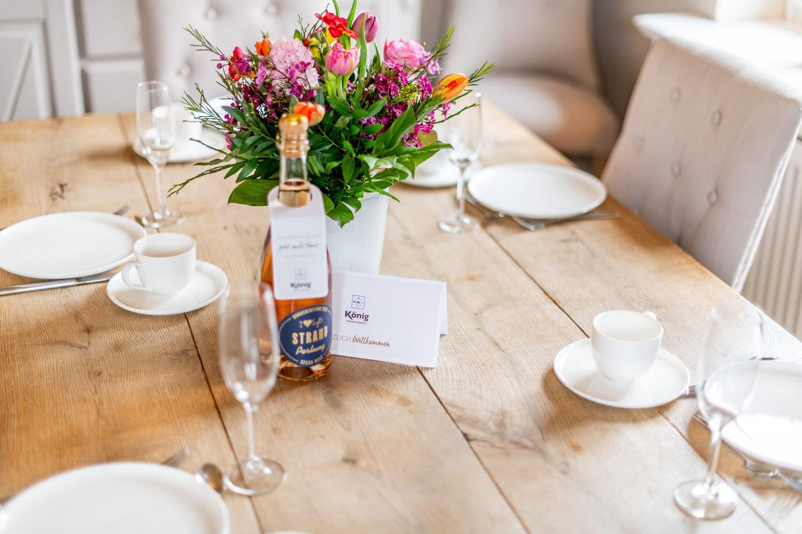 Holztisch mit Tischdekoration und Blumenstrauß