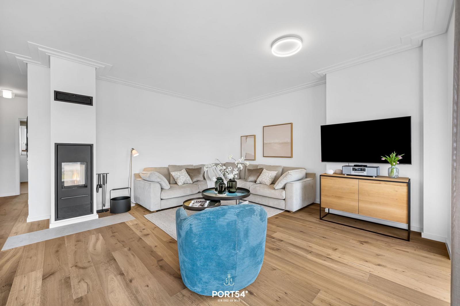 Wohnzimmer mit Sofa, Kamin und Fernseher auf Holzkonsole.