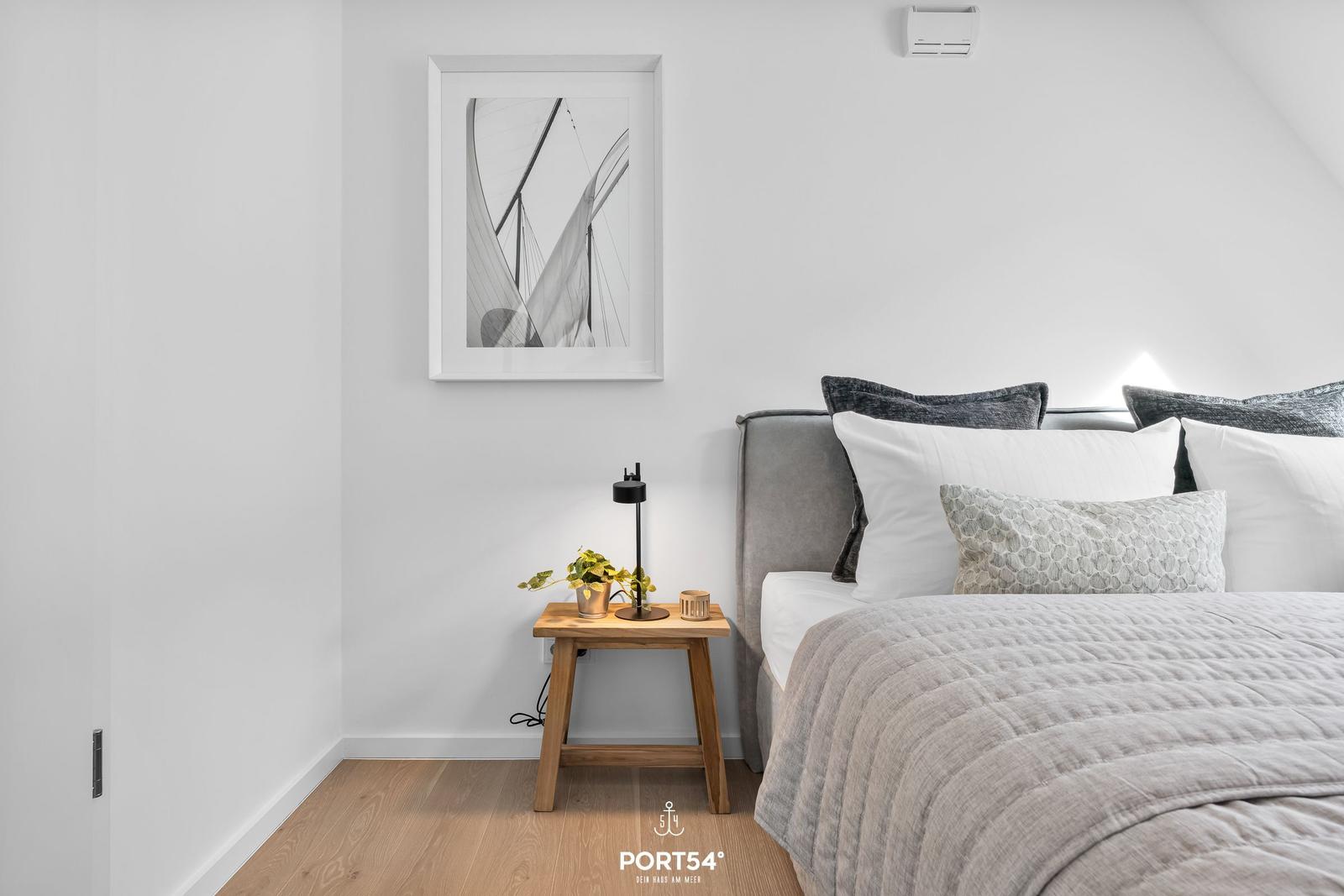 Bedroom with bed, nightstand, and wall art.