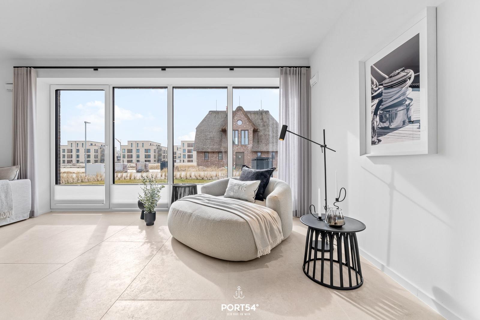 A room with large windows, seating, and wall art.