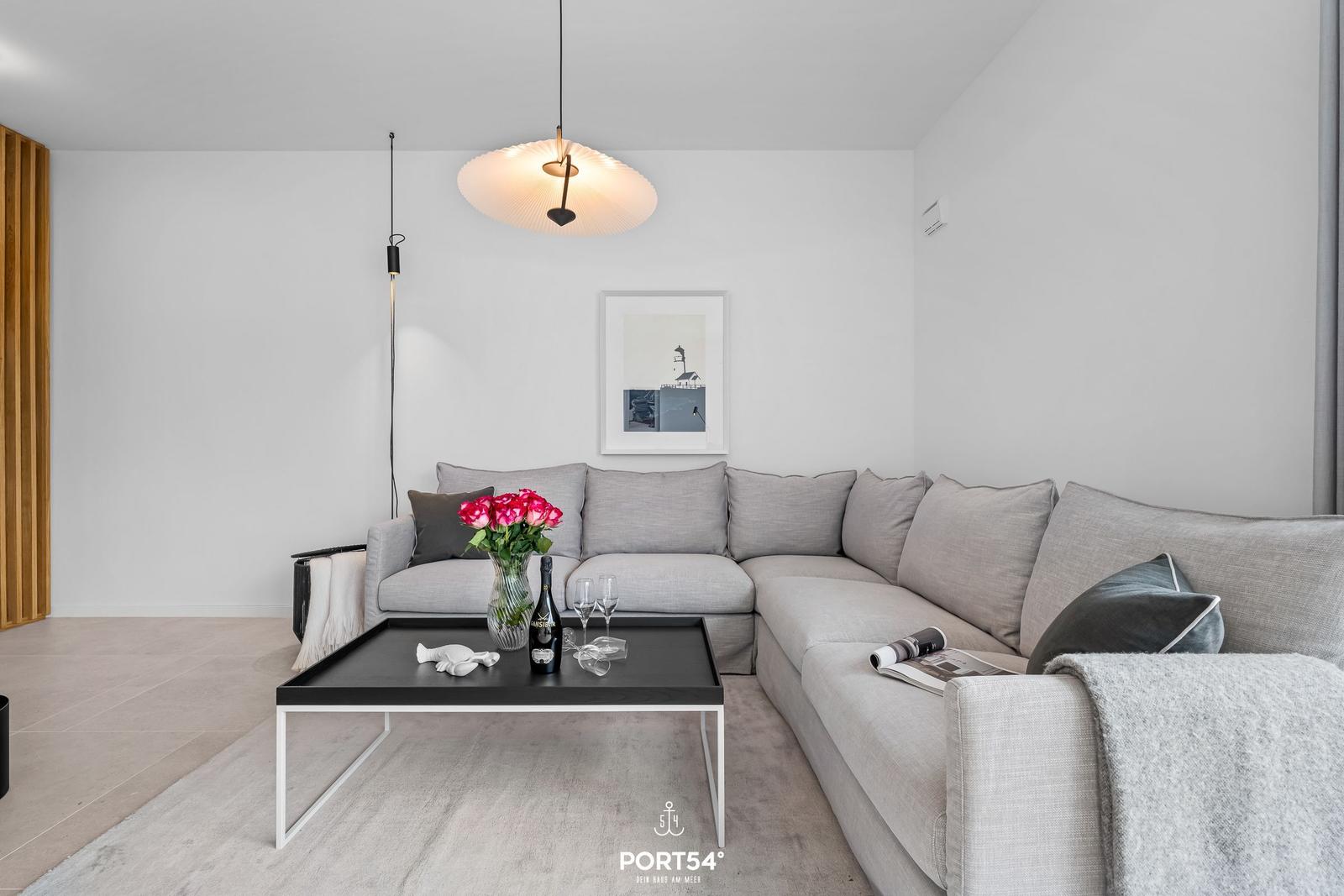 Living room with gray sofa, black coffee table, and hanging lamp.