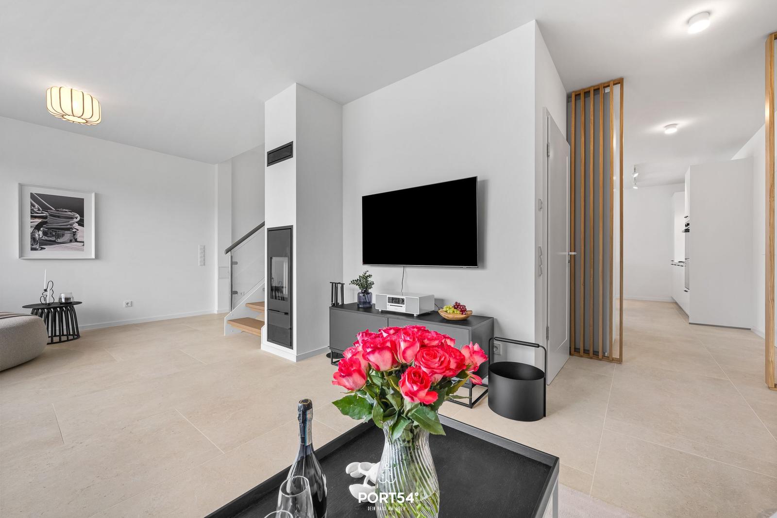 Wohnbereich mit TV, Kamin und moderner Einrichtung.