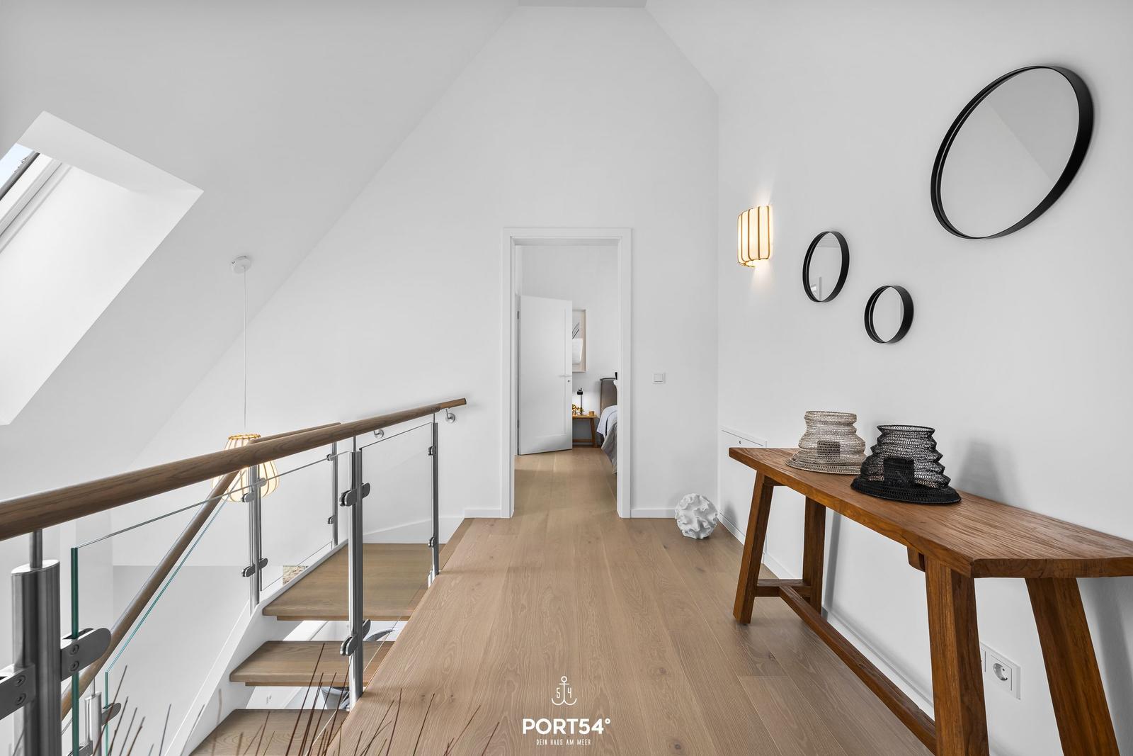 Hausflur mit Holzboden, Treppe und Wandspiegel