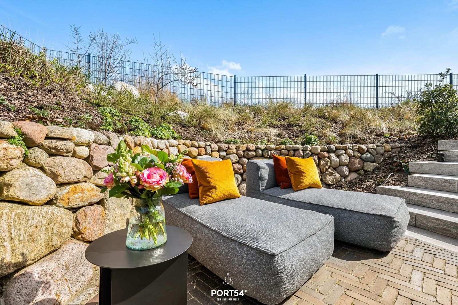 Outdoor terrace with cushions and floral arrangement