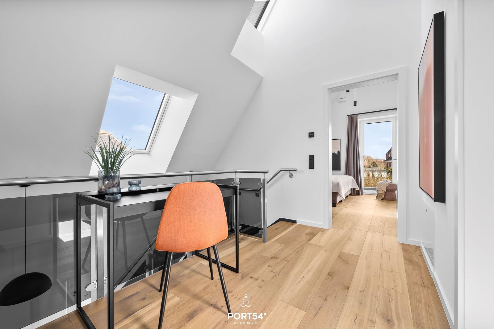 Attic with desk, orange chair, and view of the roof