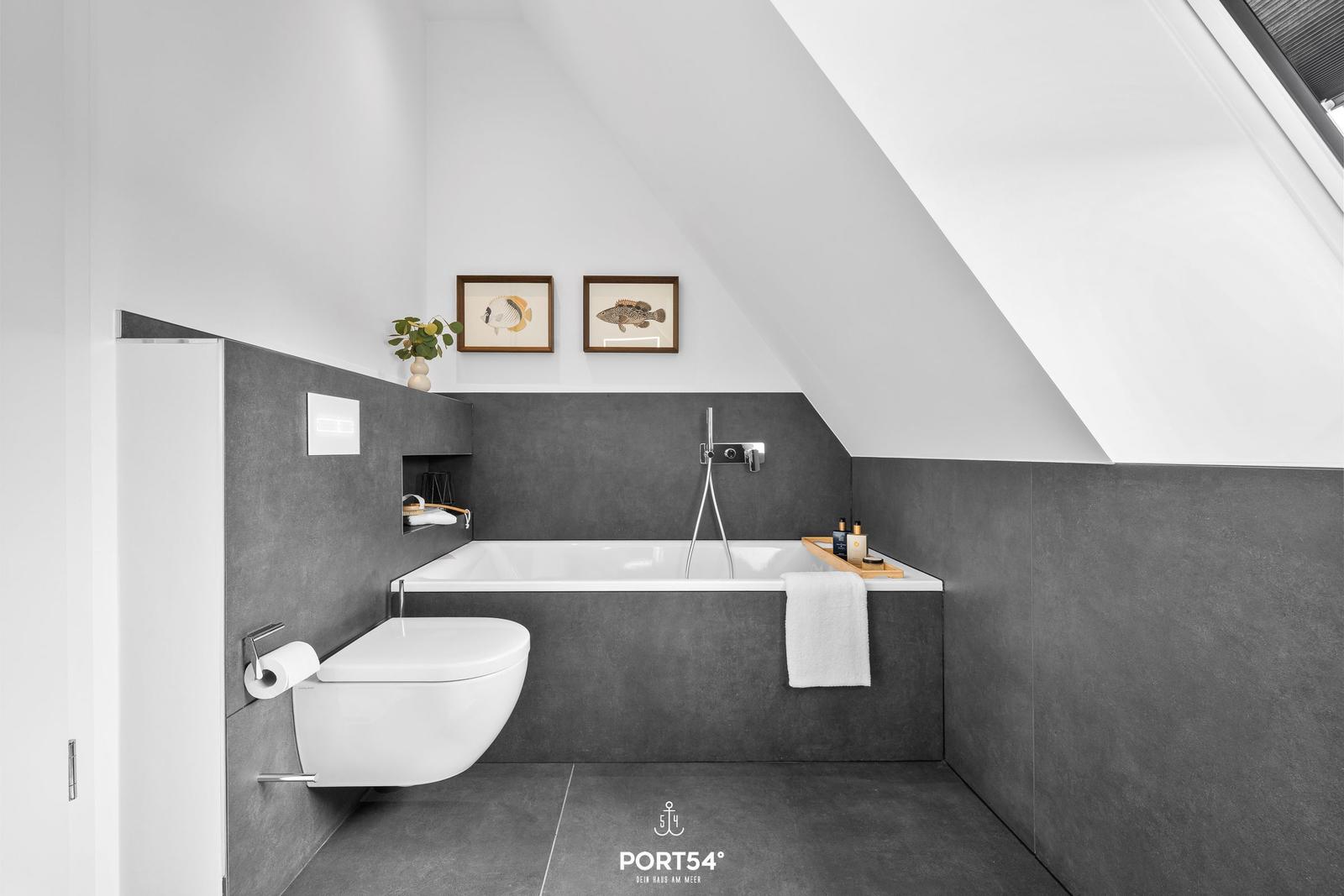 Bathroom with shower, bathtub, and toilet under sloped ceiling.