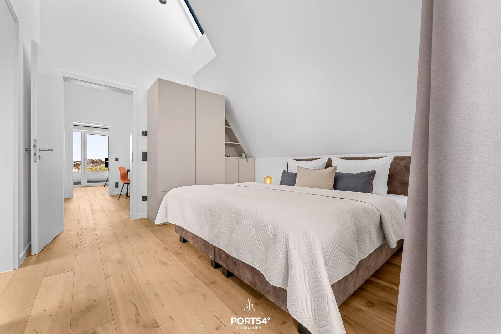 Bedroom with bed, wardrobe, and view of terrace.