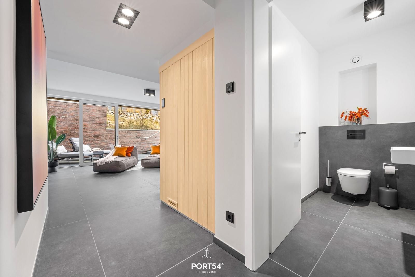 Hallway with bathroom and access to lounge with seating.