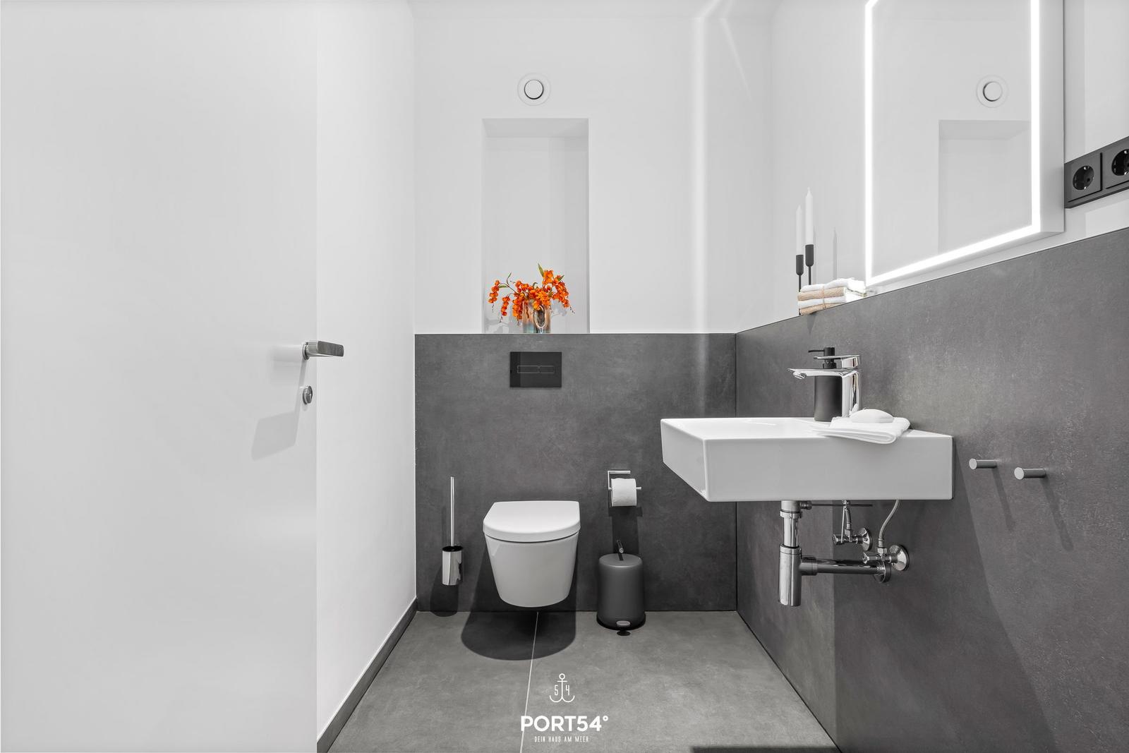 Modern bathroom with sink, toilet, and mirror