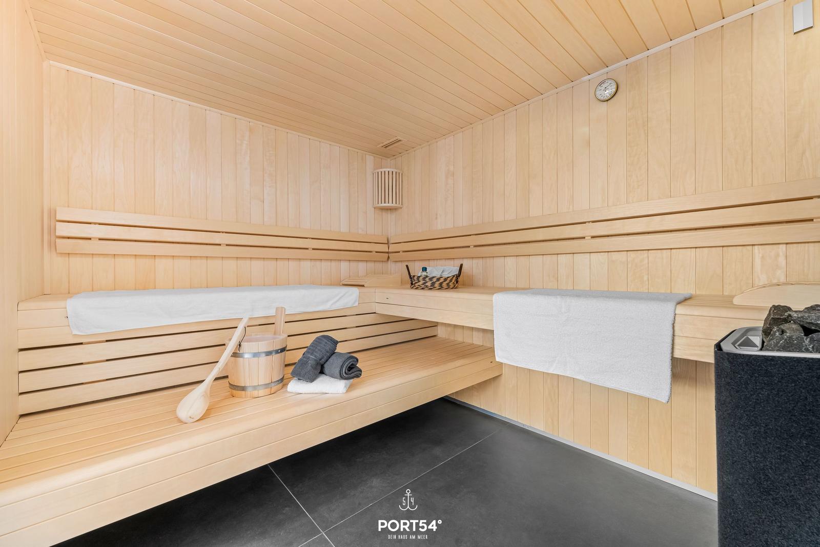 Sauna with wooden bench, towel, and water bucket