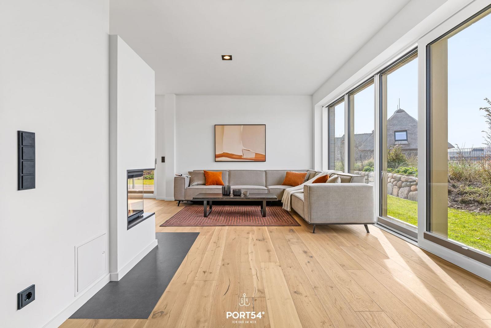 Living room with sofa, fireplace, and large window view