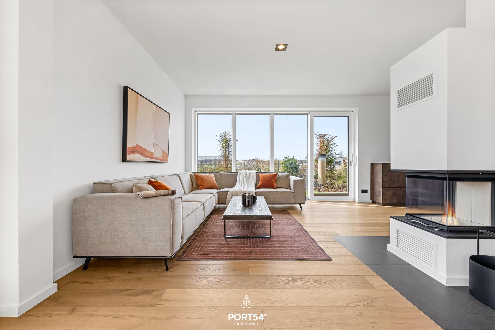 Living room with sofa, fireplace, and large window view.