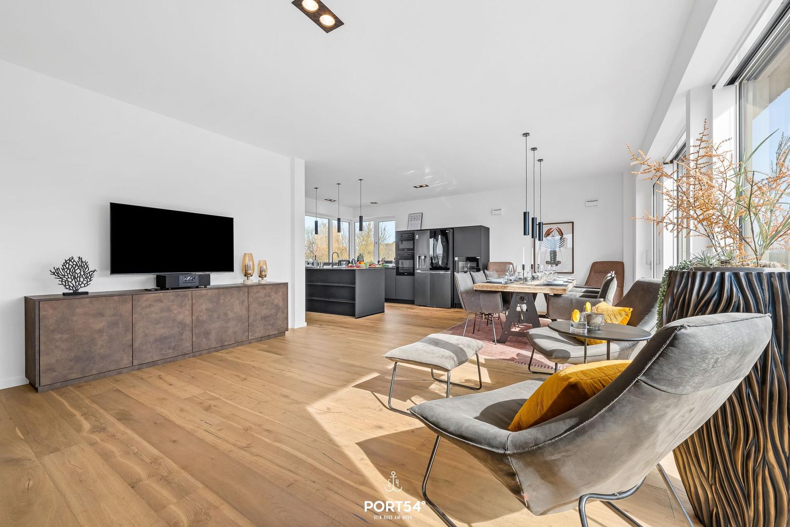 Living and dining area with modern furniture and wooden floor.