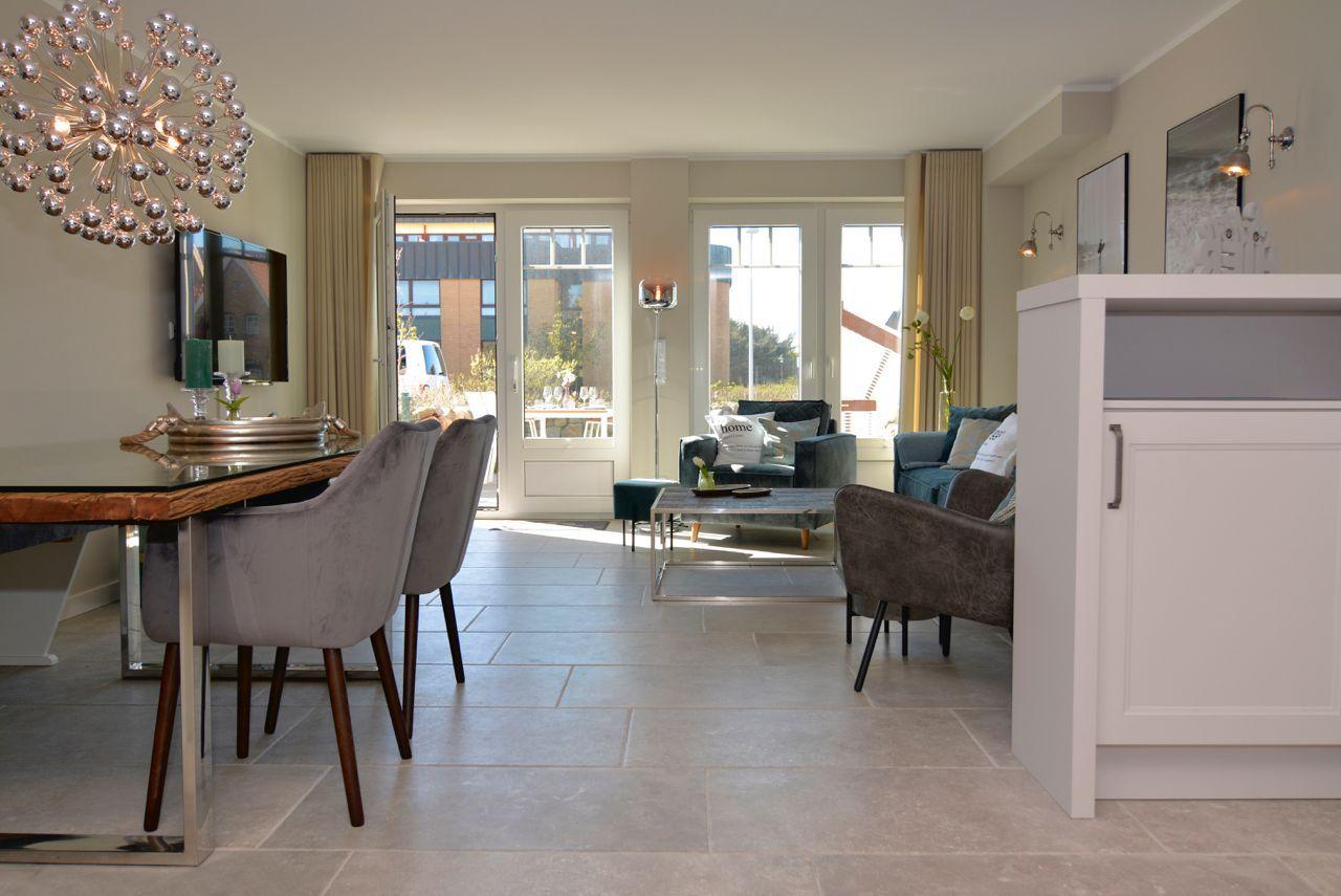 Living and dining area with seating, dining table, and glass doors to terrace.
