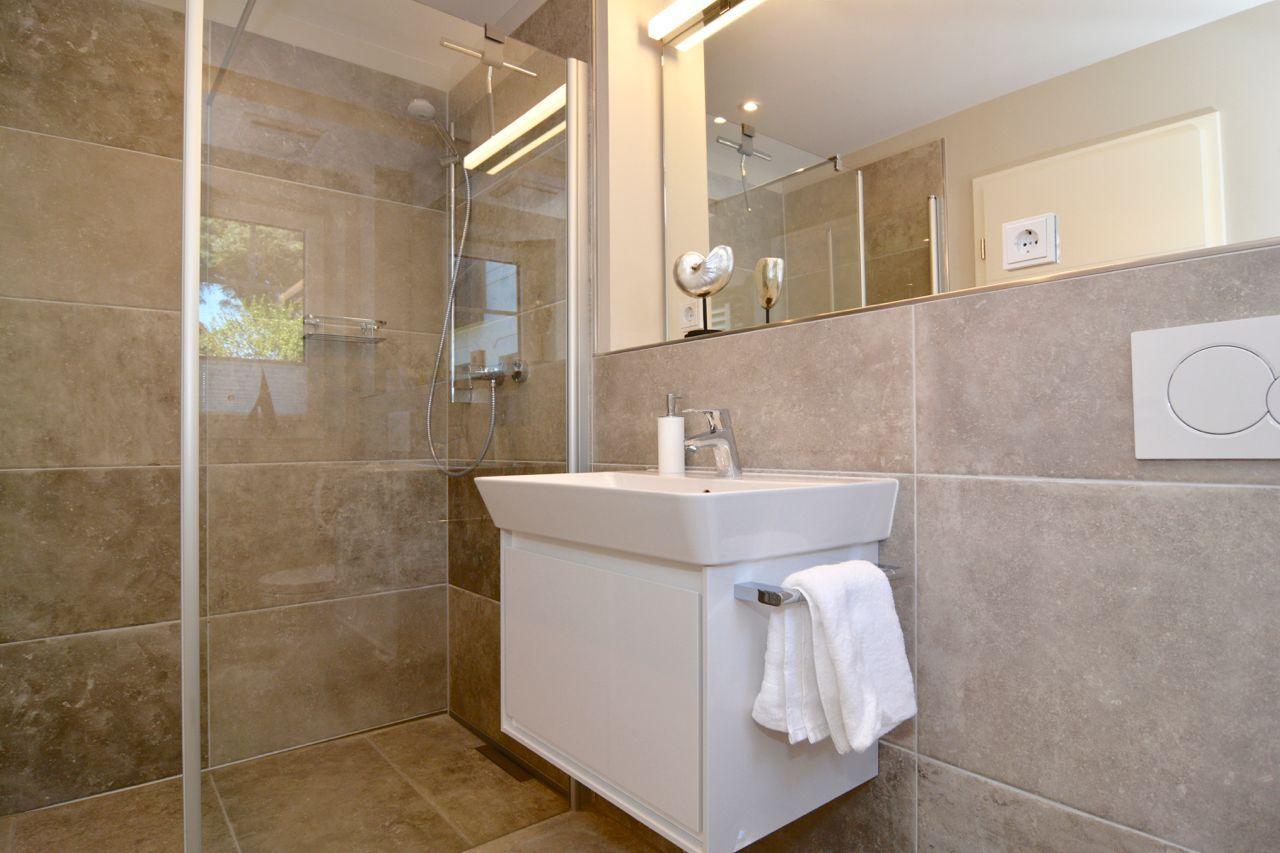 Bathroom with shower, sink, and mirror.
