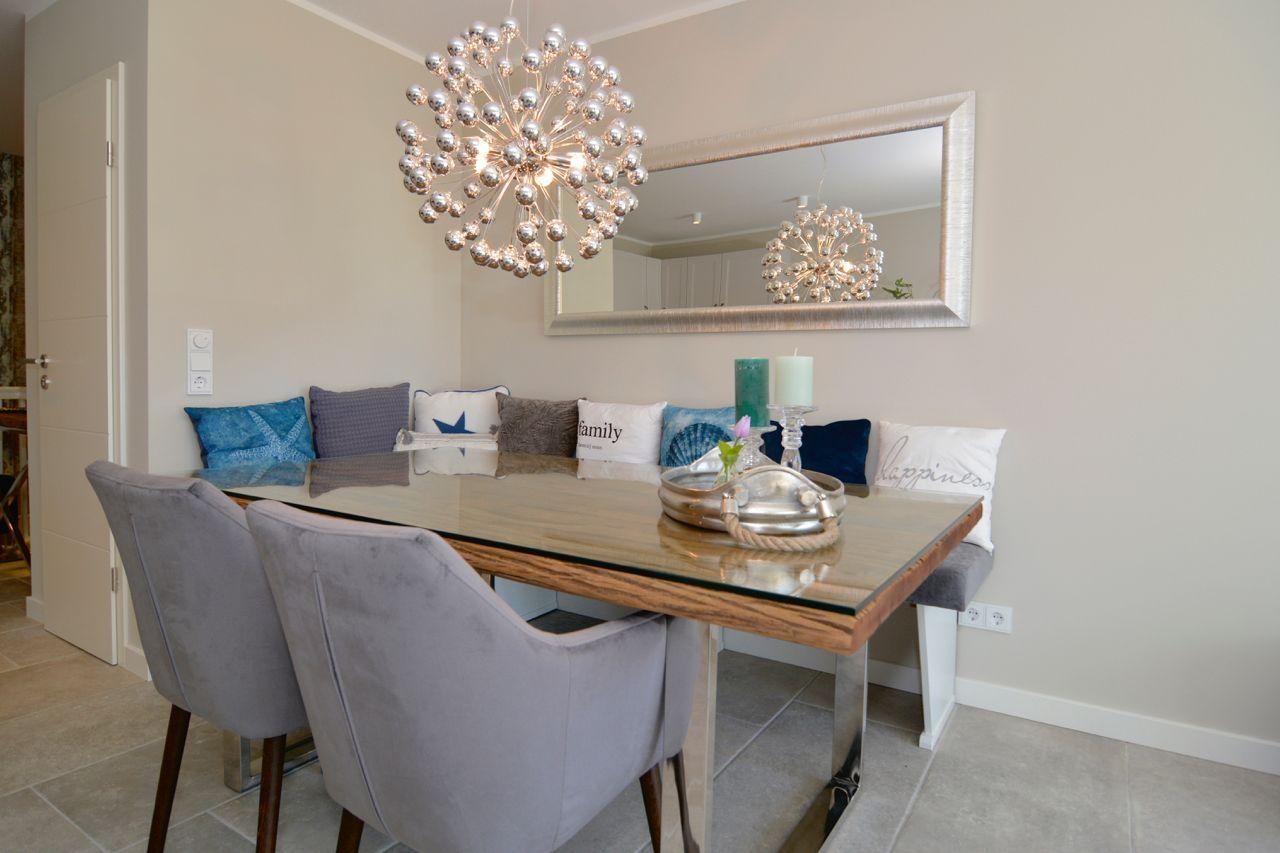 Dining room with glass top, gray chairs, and cushioned bench.