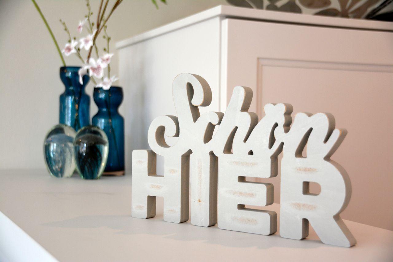 Beautiful here - wooden letters and flower vases on a white cabinet