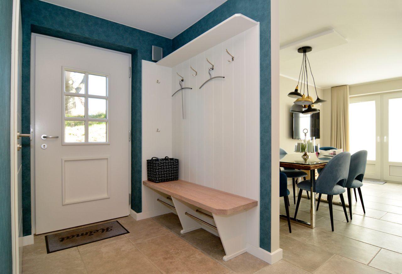 Entrance with coat rack and bench. View into dining room with table and chairs.