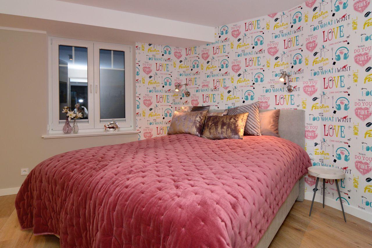 Bedroom with bed, window, and patterned wall covering.