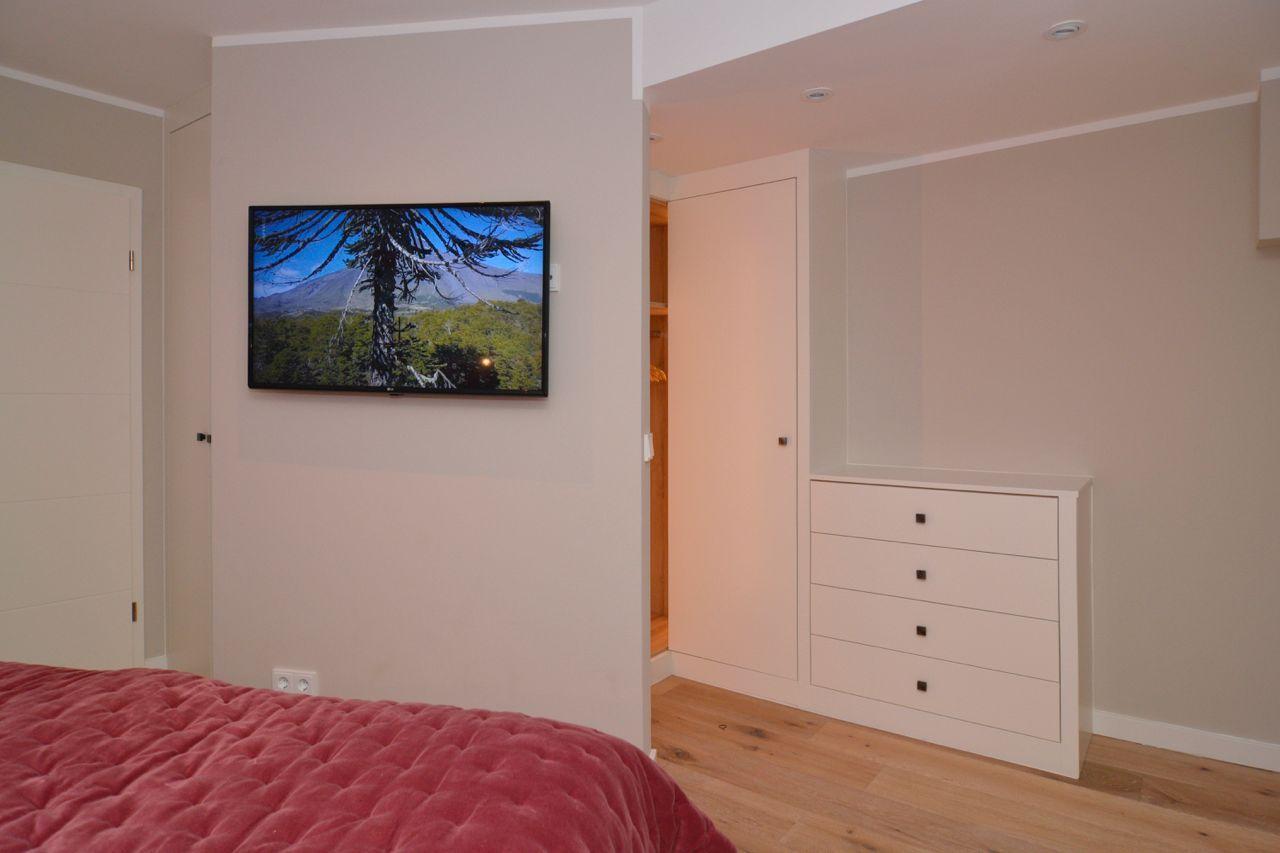 Bedroom with bed, TV, and dresser