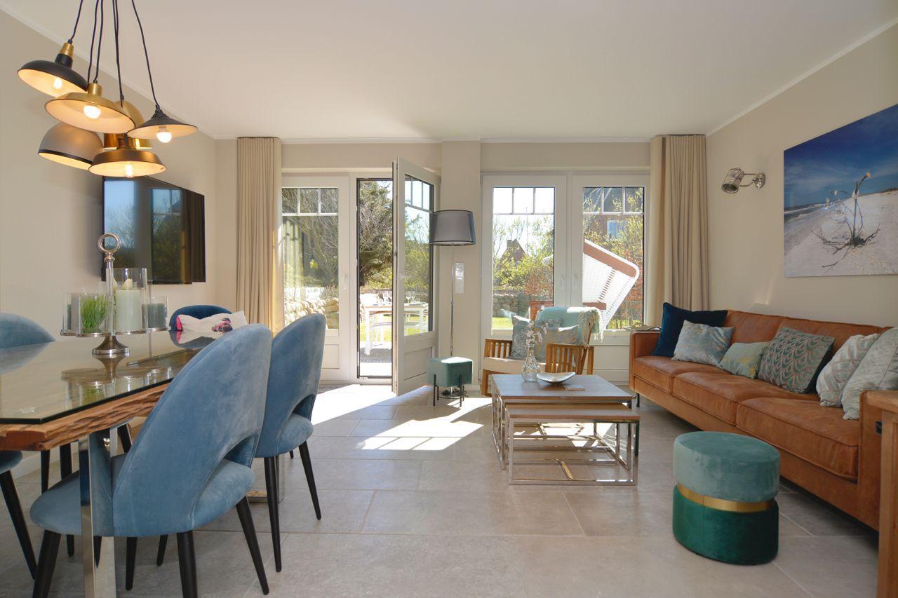 Living and dining area with sofa, dining table, and glass doors to terrace.
