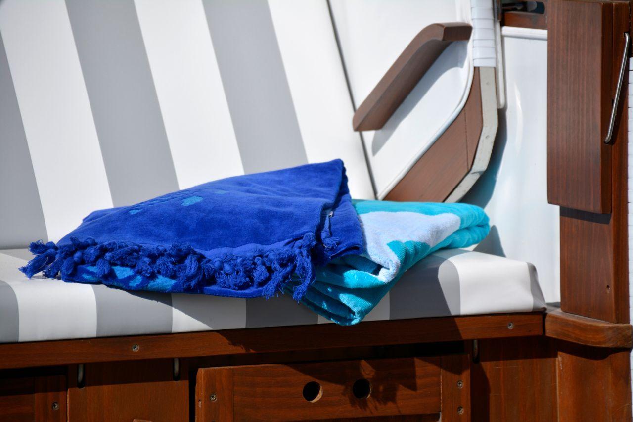 Blue and turquoise towels on striped lounge chair